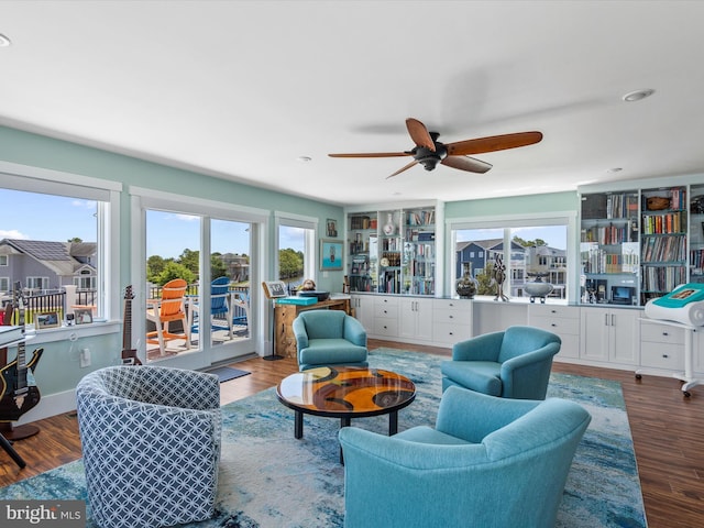 living room featuring wood-type flooring and ceiling fan