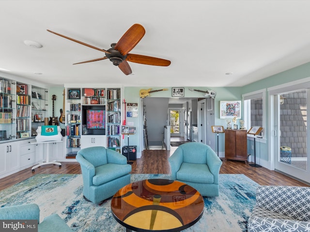 living room featuring ceiling fan and dark hardwood / wood-style flooring