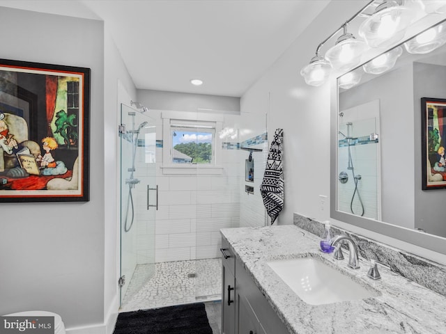 bathroom with a shower with door and vanity