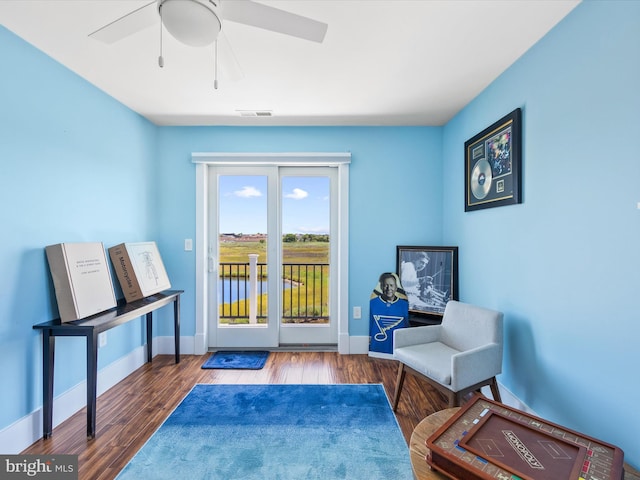 sitting room with ceiling fan and hardwood / wood-style floors