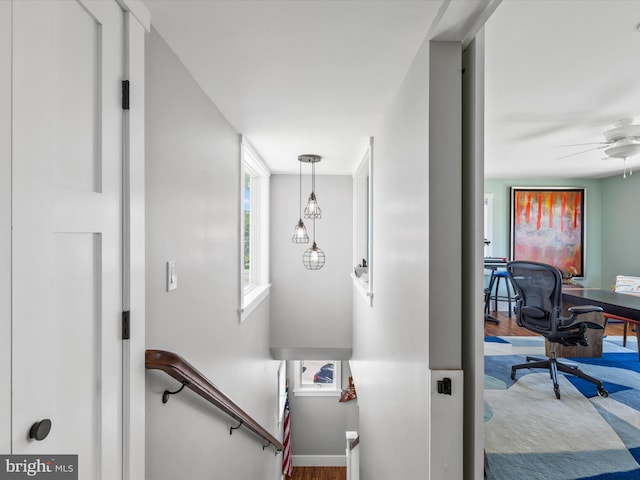 stairway featuring ceiling fan