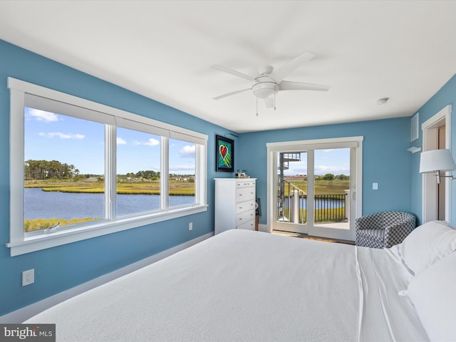 bedroom featuring ceiling fan, a water view, and access to outside