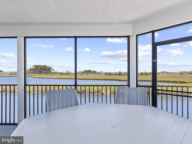 unfurnished sunroom featuring a water view