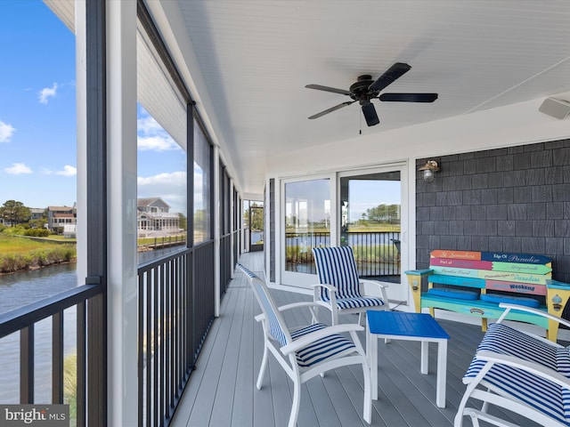 sunroom featuring a water view and ceiling fan