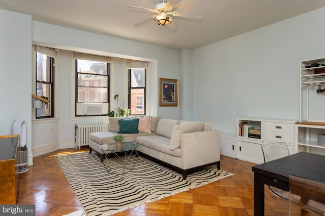 living room featuring ceiling fan, dark parquet flooring, and radiator