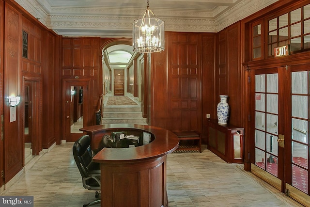 interior space featuring french doors, an inviting chandelier, ornamental molding, and wooden walls