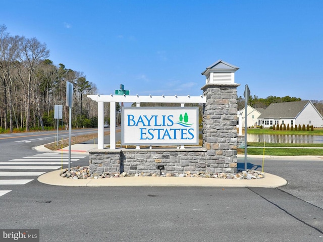 community sign featuring a water view