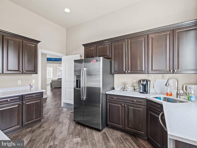 kitchen featuring dark hardwood / wood-style flooring, dark brown cabinetry, sink, and stainless steel refrigerator with ice dispenser