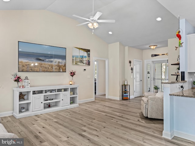 living room with ceiling fan, light wood-type flooring, and vaulted ceiling