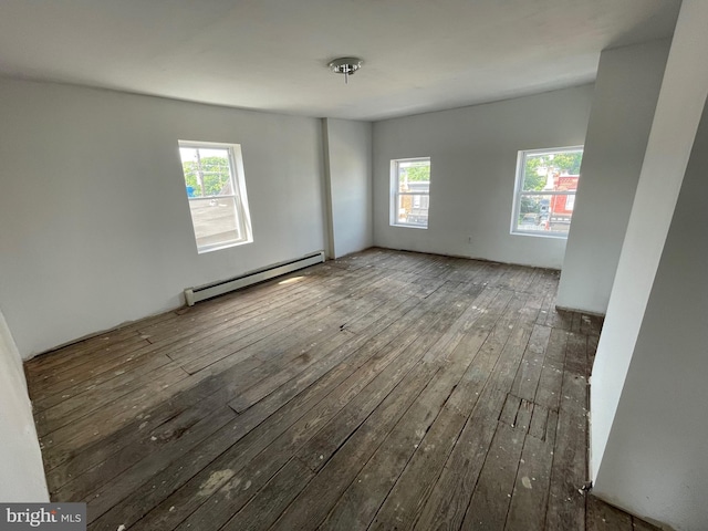 unfurnished room with wood-type flooring and a baseboard heating unit