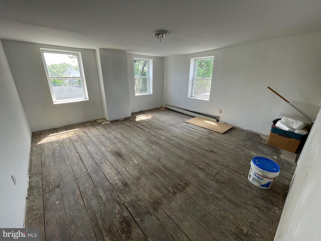 unfurnished room featuring hardwood / wood-style floors, a wealth of natural light, and a baseboard radiator