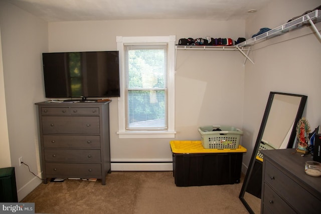 spacious closet featuring carpet floors and a baseboard heating unit