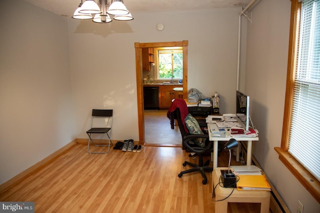 office area featuring sink, a chandelier, and light wood-type flooring