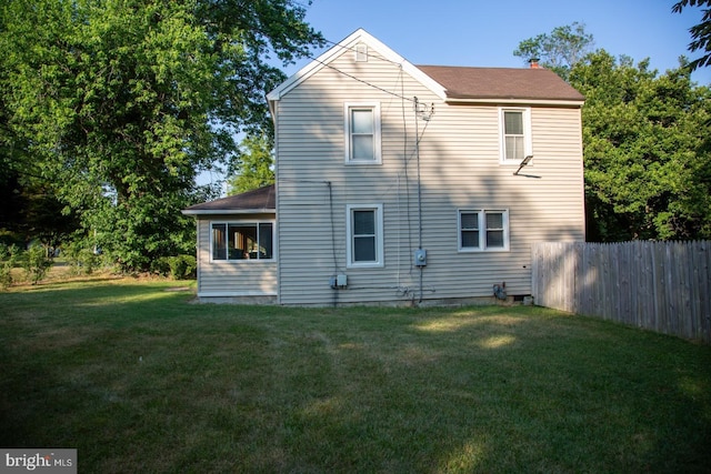 rear view of property featuring a yard