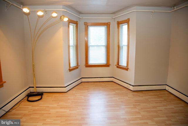 empty room with a baseboard heating unit and light wood-type flooring