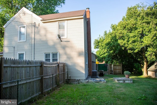 back of house featuring central AC and a lawn