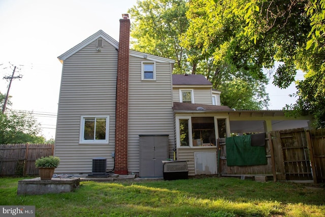 rear view of house featuring a yard and cooling unit