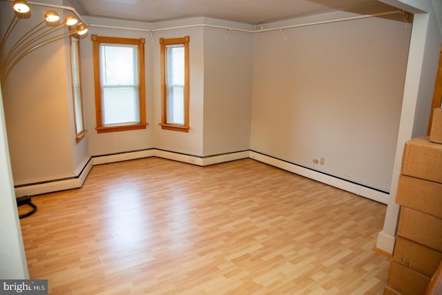 spare room featuring light hardwood / wood-style floors and a baseboard heating unit