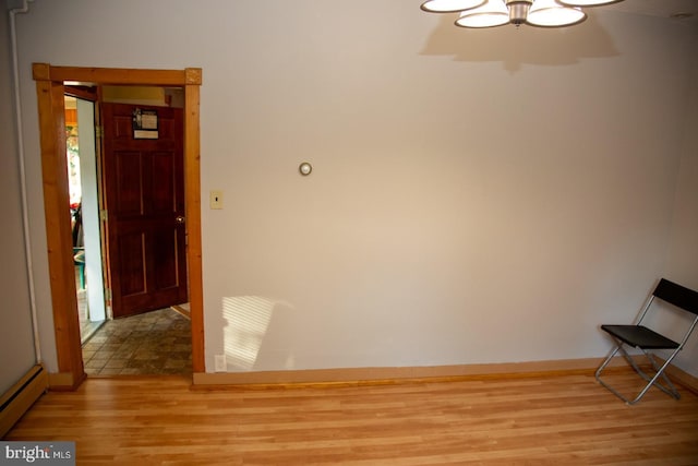 interior space with light wood-type flooring and a baseboard heating unit