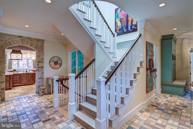 stairs featuring crown molding and sink