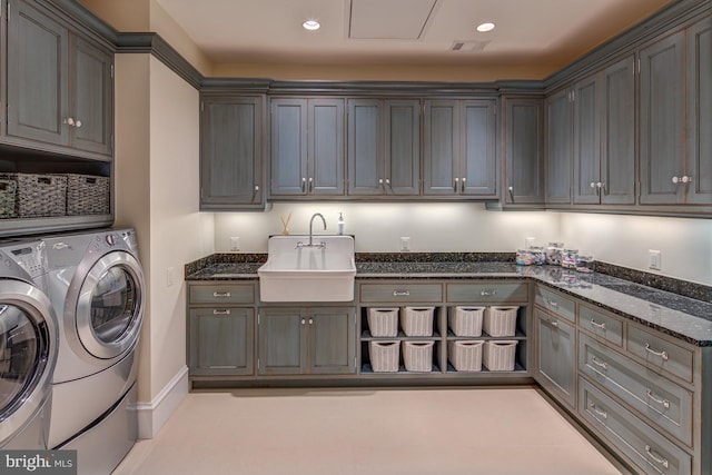 washroom with cabinets, separate washer and dryer, and sink