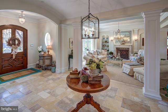 entryway with decorative columns and crown molding