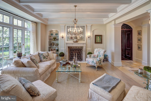 living room featuring an inviting chandelier, light wood-type flooring, built in features, a fireplace, and beamed ceiling