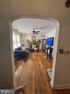 living room featuring wood-type flooring and ceiling fan