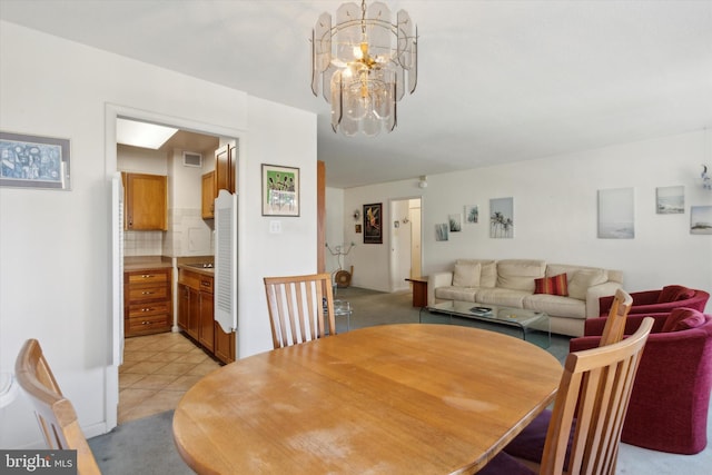 dining room with light tile patterned floors and a chandelier