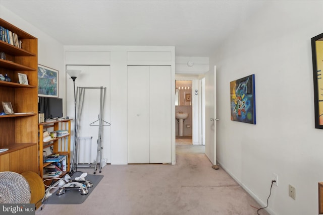 workout room featuring sink and light carpet