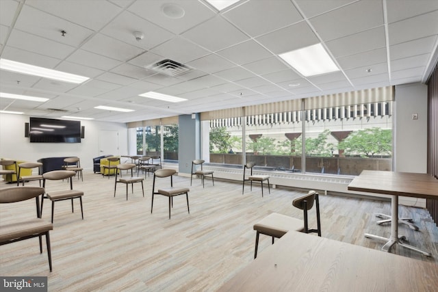 interior space featuring a drop ceiling and light hardwood / wood-style flooring