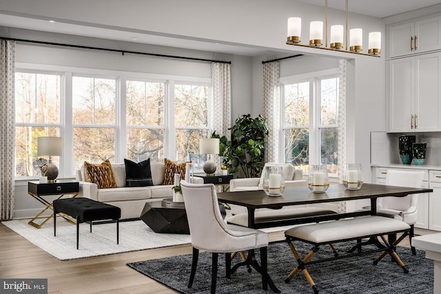 dining space with light wood-type flooring and a chandelier