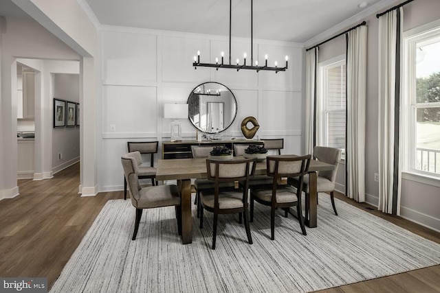 dining space featuring a healthy amount of sunlight, crown molding, and hardwood / wood-style floors