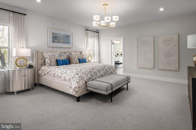 bedroom with ensuite bath, a notable chandelier, and carpet flooring