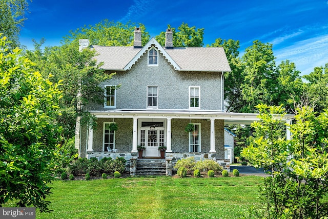 view of front of house with covered porch and a front yard