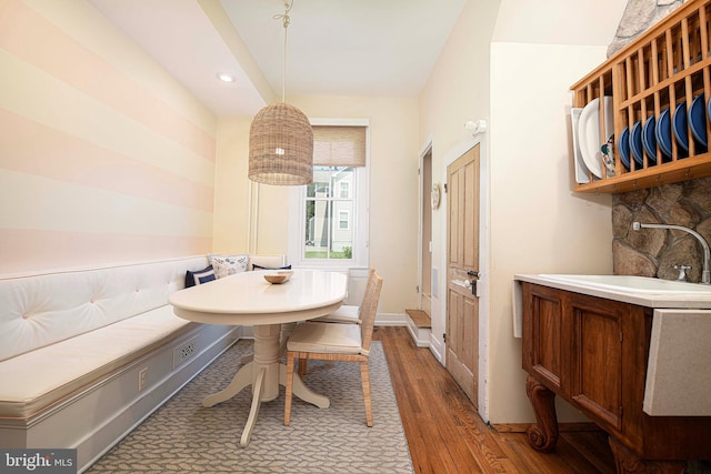 dining space with breakfast area, sink, and dark wood-type flooring