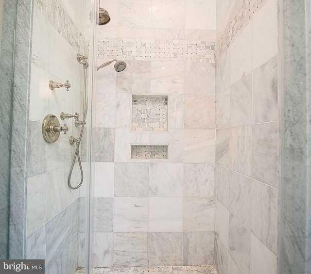 interior details featuring a tile shower