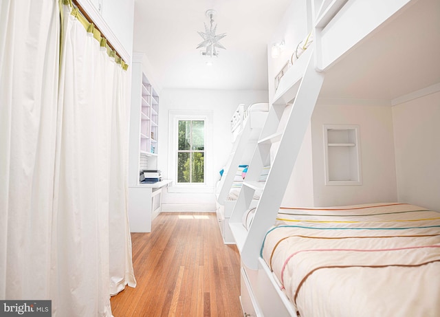 bedroom with ornamental molding and light wood-type flooring