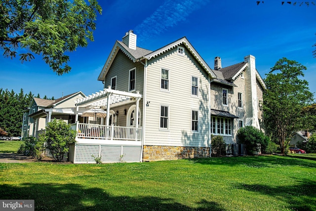 rear view of property with covered porch, a yard, a pergola, and central AC unit