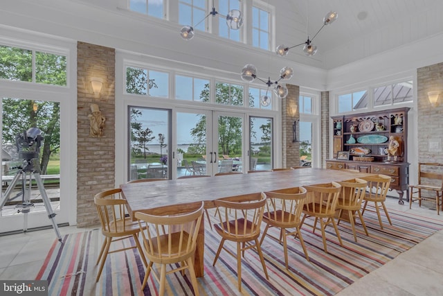 dining area featuring plenty of natural light, light tile patterned floors, and a high ceiling