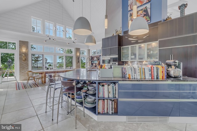 kitchen featuring pendant lighting, sink, and high vaulted ceiling