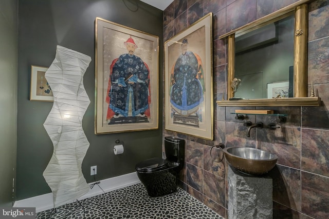 bathroom featuring tile walls and sink