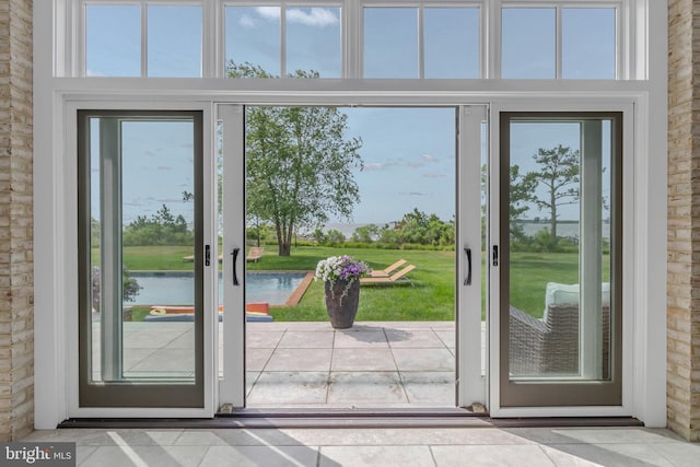 doorway to outside featuring a water view and tile patterned floors