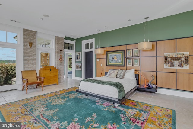 tiled bedroom featuring brick wall and access to outside