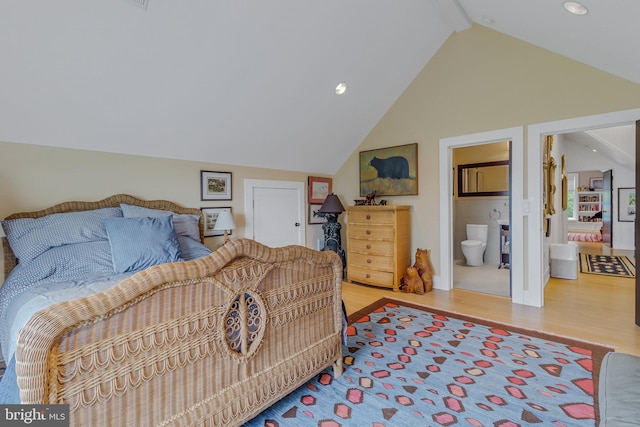 bedroom featuring connected bathroom, hardwood / wood-style floors, and lofted ceiling with beams