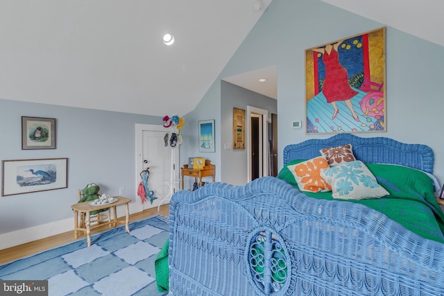 bedroom with hardwood / wood-style flooring and lofted ceiling