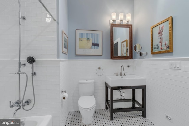 bathroom featuring sink, tile walls, and toilet