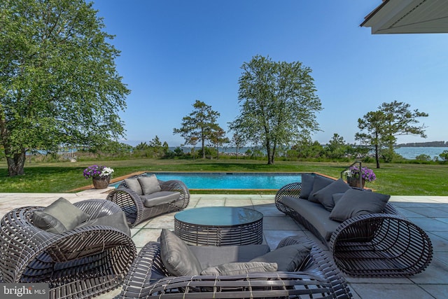 view of swimming pool with an outdoor living space, a patio area, and a water view