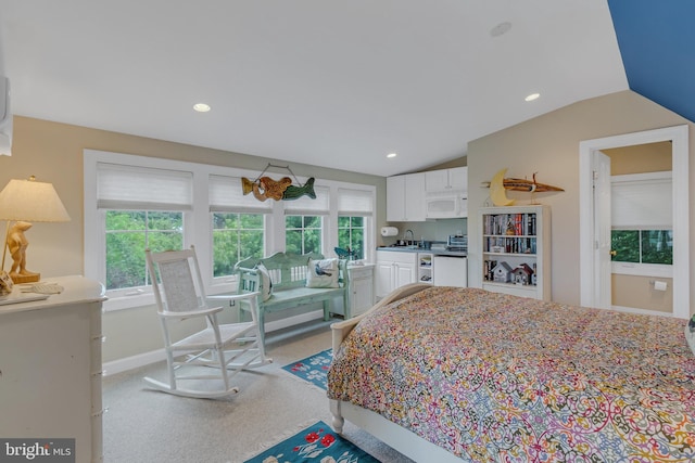 bedroom with light carpet, sink, and lofted ceiling