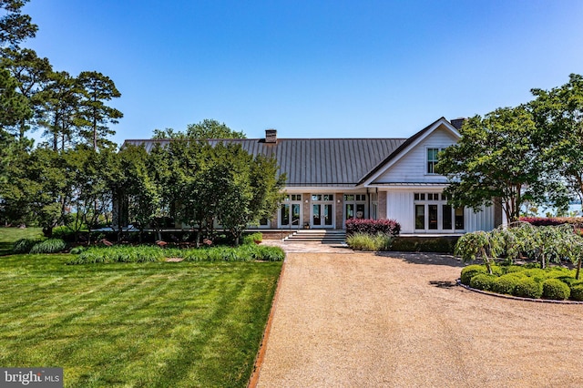 rear view of property with a lawn and french doors